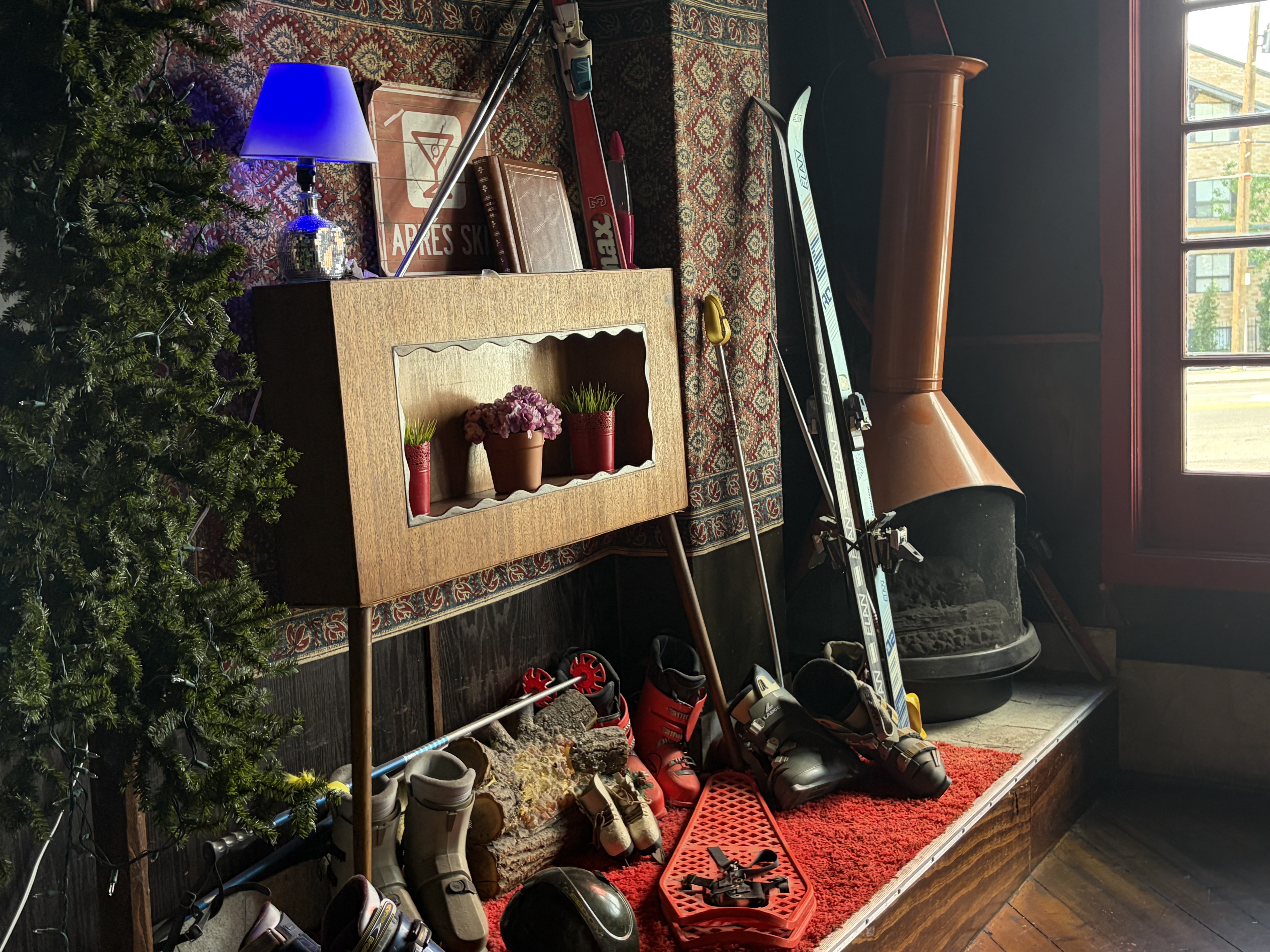 Copper cone fireplace with ski boots, poles and skis